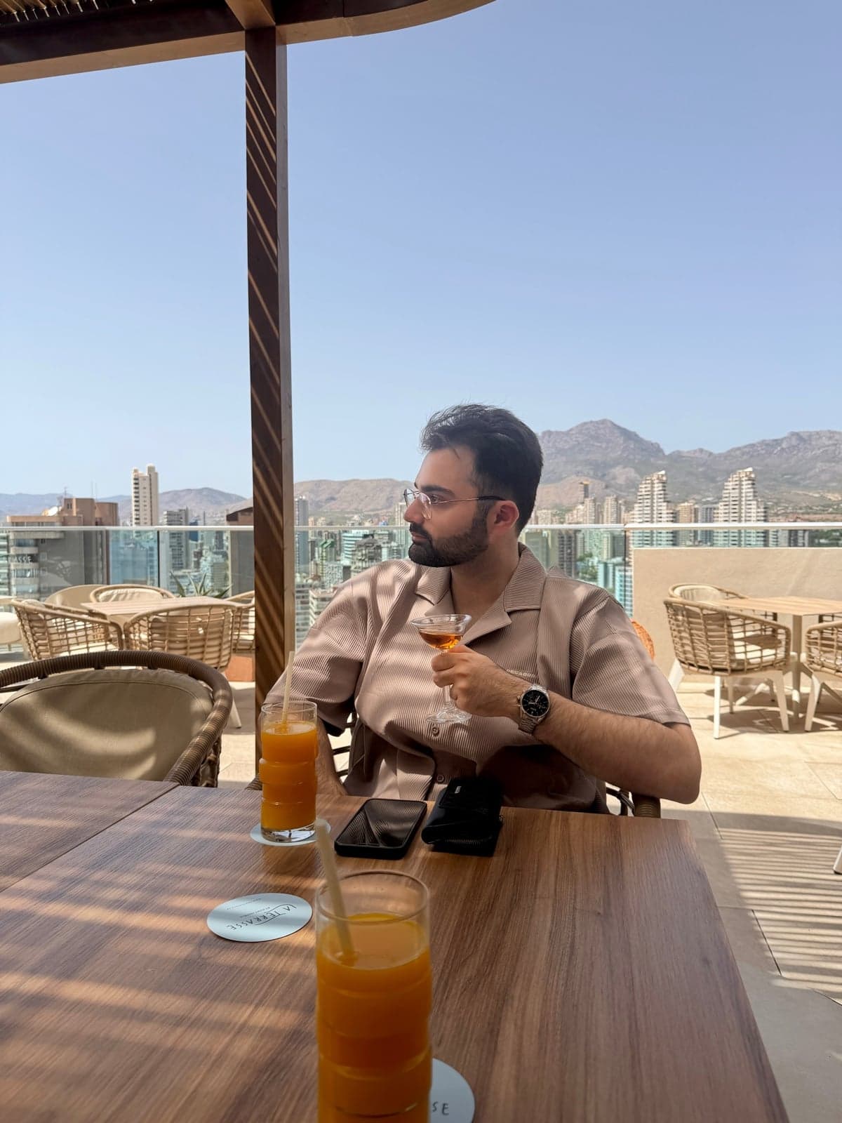 Sitting on a rooftop terrace overlooking the city and mountains